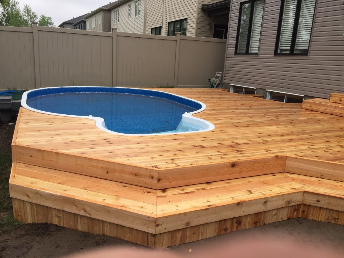 Cedar deck wrapping a backyard swimming pool