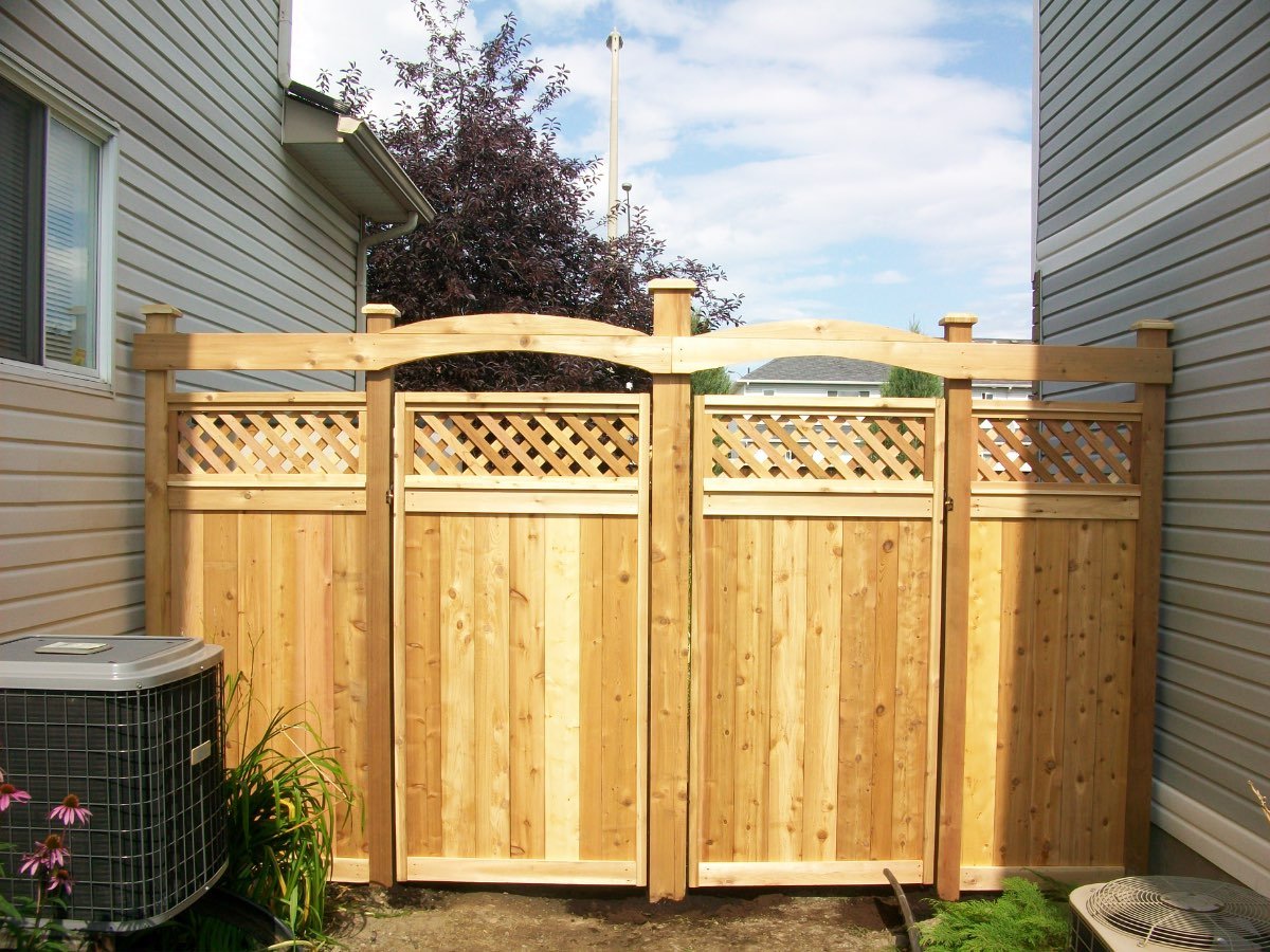 Cedar privacy fence with lattice top and an arched double gate