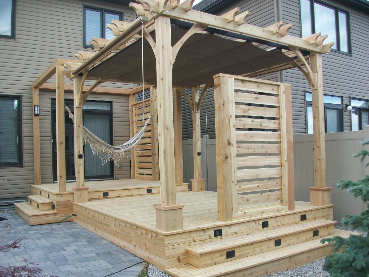 Custom cedar pergola with a hammock over a backyard deck